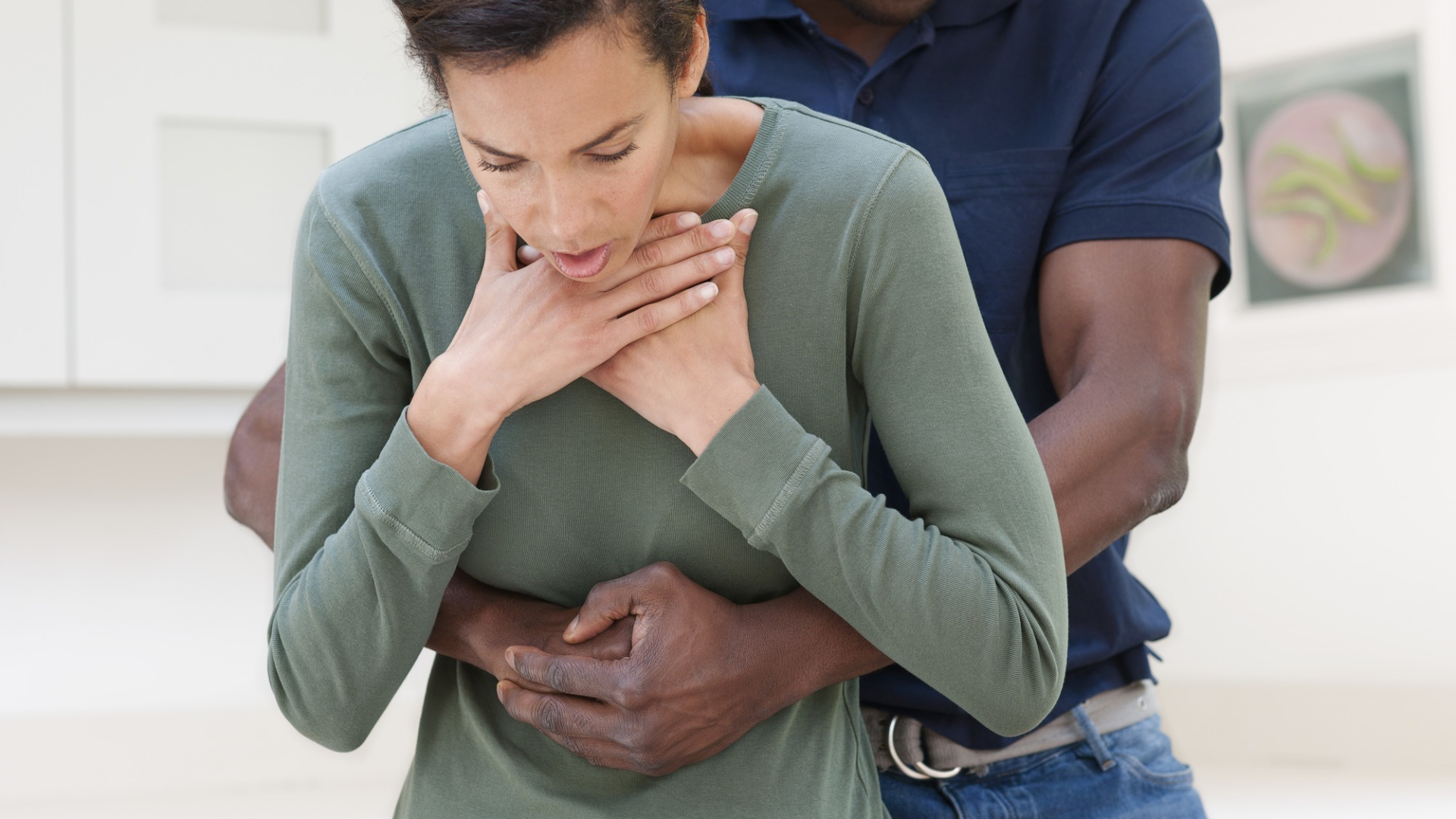 Nella foto c'è un ragazzo che esegue la manovra di Heimlich ad una ragazza che si tiene la gola fra le mani ad indicare che sta soffocando