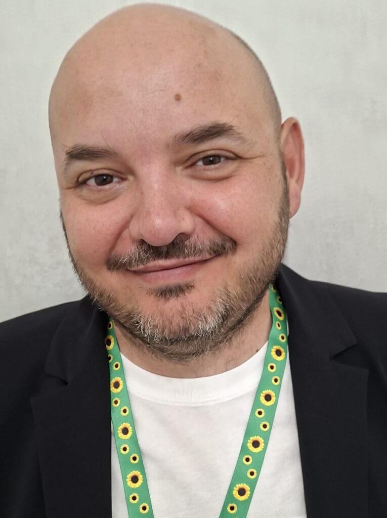 Foto di Manfredo in primo piano. Al collo ha il cordino Sunflower verde